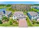 Aerial view of a two-story home with brick driveway, three-car garage, manicured lawn and lush backyard at 11086 Sundrift Dr, Tampa, FL 33647