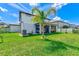 Large backyard features a covered patio, healthy green grass, and mature trees at 11086 Sundrift Dr, Tampa, FL 33647