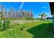 A large fenced backyard features healthy green grass, garden areas, and mature trees at 11086 Sundrift Dr, Tampa, FL 33647