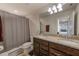 Bathroom features double sinks, granite counters, and shower with grey curtain at 11086 Sundrift Dr, Tampa, FL 33647