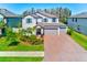 Beautiful two-story home with brick driveway, three-car garage, manicured lawn and charming curb appeal at 11086 Sundrift Dr, Tampa, FL 33647