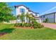 Well-manicured front yard, lush landscaping, and a brick driveway enhance the curb appeal of this home at 11086 Sundrift Dr, Tampa, FL 33647