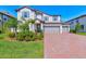 Charming two-story home featuring a three-car garage, manicured lawn, and beautiful landscaping at 11086 Sundrift Dr, Tampa, FL 33647