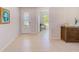 Bright foyer with tile flooring, decorative front door, and view of adjacent home office at 11086 Sundrift Dr, Tampa, FL 33647