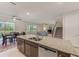 Kitchen island with granite countertop, sink, and stainless steel dishwasher in an open-concept space at 11086 Sundrift Dr, Tampa, FL 33647