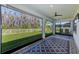 Enclosed lanai boasts tile floors, ceiling fan, and stunning backyard views at 11086 Sundrift Dr, Tampa, FL 33647