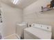Well-lit laundry room with washer, dryer, and storage shelves at 11086 Sundrift Dr, Tampa, FL 33647
