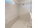 Shower stall features neutral tile, glass enclosure, window, and modern fixture at 11086 Sundrift Dr, Tampa, FL 33647