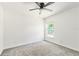 Bright bedroom features a ceiling fan, natural light from a window, and neutral-colored carpeting at 1150 Waterfall Dr, Spring Hill, FL 34608