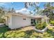 Side exterior view of home featuring manicured garden bed and mature trees at 1150 Waterfall Dr, Spring Hill, FL 34608