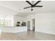 Open-concept living room featuring lots of light, modern ceiling fan, and wood-look flooring at 1150 Waterfall Dr, Spring Hill, FL 34608