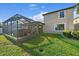 View of the back of the home, showing the screened patio and lush green grass at 13325 Sunset Shore Cir, Riverview, FL 33579