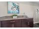 Granite countertop bar area with dark wood cabinets and a turtle art piece at 13325 Sunset Shore Cir, Riverview, FL 33579