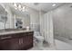 Bright bathroom with dark vanity, tub-shower combo, and silver fixtures at 13325 Sunset Shore Cir, Riverview, FL 33579