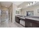 This spacious bathroom includes double sinks, granite countertops, a walk-in shower, and tile floors at 13325 Sunset Shore Cir, Riverview, FL 33579