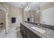 A well-lit full bathroom offers a shower-tub combination, single vanity, and a granite countertop at 13325 Sunset Shore Cir, Riverview, FL 33579