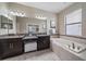 This spacious bathroom includes double sinks, granite countertops, a soaking tub, and a large mirror at 13325 Sunset Shore Cir, Riverview, FL 33579