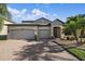 Beautiful home exterior featuring a brick driveway, manicured lawn, and a two-car garage, perfect for curb appeal at 13325 Sunset Shore Cir, Riverview, FL 33579