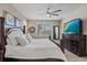 A stunning main bedroom features a ceiling fan, a large television, and luxury furnishings at 13325 Sunset Shore Cir, Riverview, FL 33579