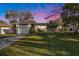 Charming single-story home with a well-manicured lawn and a two-car garage at sunset at 1424 Orange St, Clearwater, FL 33756