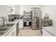 Updated kitchen features stainless steel appliances, white cabinetry, tile floors, and modern lighting at 1424 Orange St, Clearwater, FL 33756