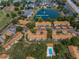 Beautiful aerial view of a condo community with mature landscaping, pool, and access to pond at 1438 Millstream Ln # 201, Dunedin, FL 34698