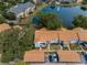 Aerial view of the complex with a lake, pool, and covered parking spaces at 1438 Millstream Ln # 201, Dunedin, FL 34698