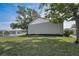 Spacious backyard with lush green lawn overlooking a serene lake with a fountain, creating a peaceful setting at 1438 Millstream Ln # 201, Dunedin, FL 34698