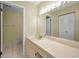 Bright bathroom with large mirror, white vanity, and tile floors at 1438 Millstream Ln # 201, Dunedin, FL 34698