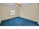 Comfortable bedroom with window, fan, and blue carpet at 1438 Millstream Ln # 201, Dunedin, FL 34698