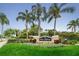 Entrance sign for Lake Tiffany with lush landscaping and palm trees at 1438 Millstream Ln # 201, Dunedin, FL 34698