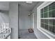 Condo entryway with gray walls, white trim, welcome mat and natural light from the large window at 1438 Millstream Ln # 201, Dunedin, FL 34698
