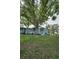Well-maintained building with patios and large trees adding shade to a lush green lawn at 1438 Millstream Ln # 201, Dunedin, FL 34698