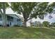 Exterior view of condominium complex with well-manicured lawn and mature shade trees at 1438 Millstream Ln # 201, Dunedin, FL 34698