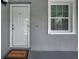 Close-up of the unit front door with a welcome mat and a window to the right at 1438 Millstream Ln # 201, Dunedin, FL 34698