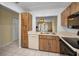 Traditional kitchen with wood cabinets, white appliances, and tile flooring at 1438 Millstream Ln # 201, Dunedin, FL 34698