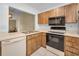 Functional kitchen with wood cabinetry, black appliances, a sink, and bright lighting at 1438 Millstream Ln # 201, Dunedin, FL 34698