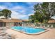Community pool surrounded by deck chairs and fenced for privacy at 1438 Millstream Ln # 201, Dunedin, FL 34698