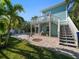 Beautiful backyard featuring a well-maintained lawn, brick patio, and poolside lounging area at 16109 3Rd E St, Redington Beach, FL 33708