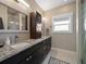 Bathroom featuring double sinks, granite countertops and a glass-enclosed shower at 16109 3Rd E St, Redington Beach, FL 33708