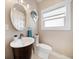 Bathroom featuring an oval mirror, pedestal sink, toilet, neutral wall paint, and a window at 16109 3Rd E St, Redington Beach, FL 33708