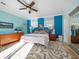 Comfortable bedroom featuring a ceiling fan, an ensuite bathroom and a light blue and dark blue accent wall at 16109 3Rd E St, Redington Beach, FL 33708