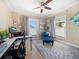 Bright bedroom featuring two windows with a decorative chaise lounge, desk and a ceiling fan at 16109 3Rd E St, Redington Beach, FL 33708