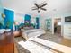 Comfortable bedroom featuring an ensuite bathroom, ceiling fan and light blue and dark blue accent wall at 16109 3Rd E St, Redington Beach, FL 33708