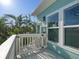 Close-up of deck with railings, a small gate, and view of surrounding palm trees at 16109 3Rd E St, Redington Beach, FL 33708