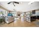 Bright, open-concept living room and kitchen features hardwood floors, ceiling fans, and modern décor at 16109 3Rd E St, Redington Beach, FL 33708