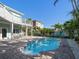 Backyard pool featuring brick paved patio area, outdoor seating, and tropical landscaping at 16109 3Rd E St, Redington Beach, FL 33708