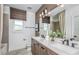 Bright bathroom featuring double sinks, quartz countertop, and woven shades at 1672 Valier Pt, Zephyrhills, FL 33541