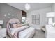 Stylish bedroom with a pink headboard, decorative pillows, and a cozy reading corner at 1672 Valier Pt, Zephyrhills, FL 33541