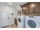 Functional laundry room with washer, dryer, and custom wood cabinetry at 1672 Valier Pt, Zephyrhills, FL 33541